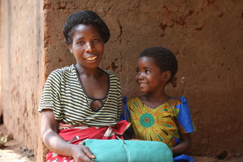 Thandizo and her mother receive mosquito nets to protect them from malaria. 