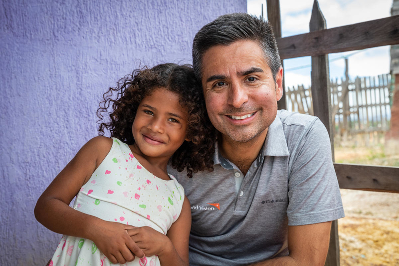 Migrant girl with World Vision president