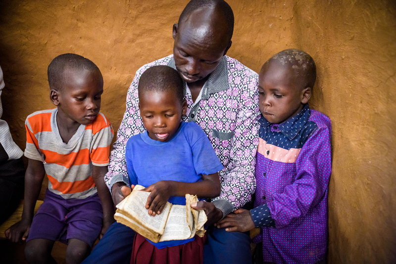Man reading with kids in Kenya