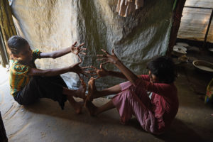 Photo: Two Rohingya girls play the "jumping game" inside a tent at Cox's Bazar settlement in Bangladesh. ©2017 World Vision, Annila Harris.