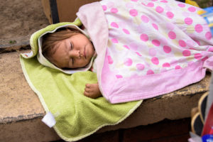 Baby sleeps next to her mother's outdoor vending stall, on the street in Tegucigalpa, Honduras. ©2018 World Vision/photo by Jon Warren