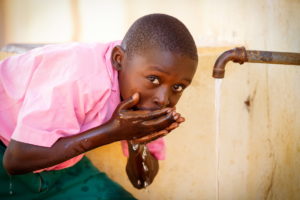 Duncan Randu, 13, lives with his mom, Racheal, and three siblings near Marafa. Until just a couple of years ago, they collected dirty water from a source about two kilometers away. Now Duncan collects water just a 2-minute walk down the street at the kiosk World Vision installed after drilling a borehole in their community.