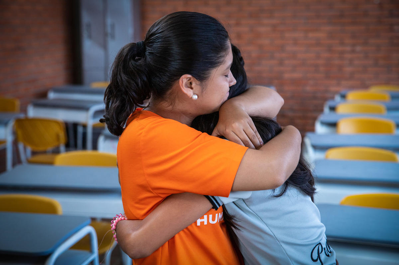 Staff hugs a young girl in Colombia