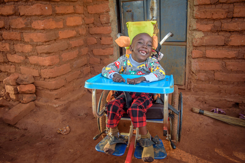 Dennis in his wheelchair from World Vision and USAID.