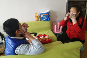 teacher helps child put on mask