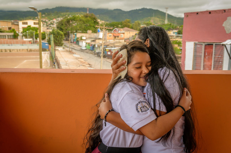 Young girl gets a hug at a church in Honduras