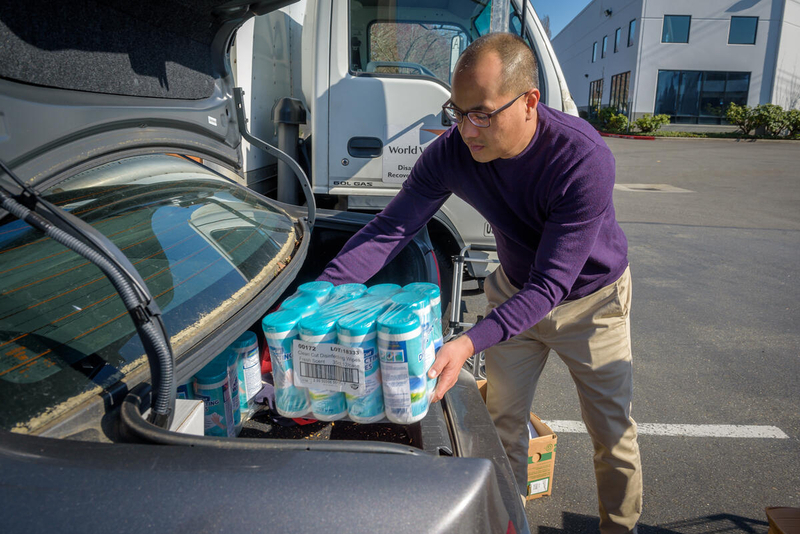 Dave loads sanitation supplies into his trunk. 