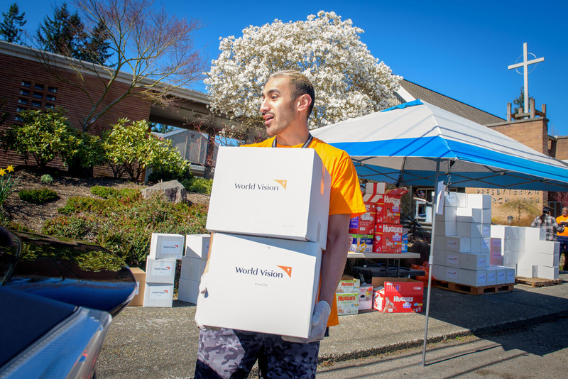 Man helps load emergency kits. 