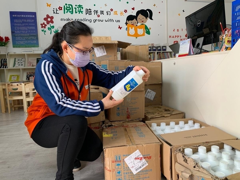 Health worker examines sanitation supplies. 