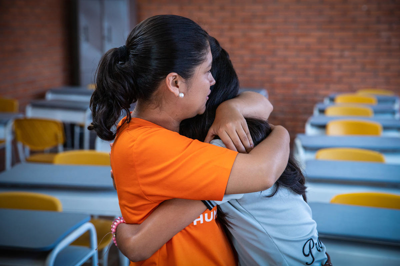 World Vision staff hugs girl in Colombia