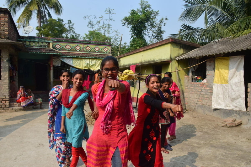 Women and girls in Bangladesh pose to show power against violence