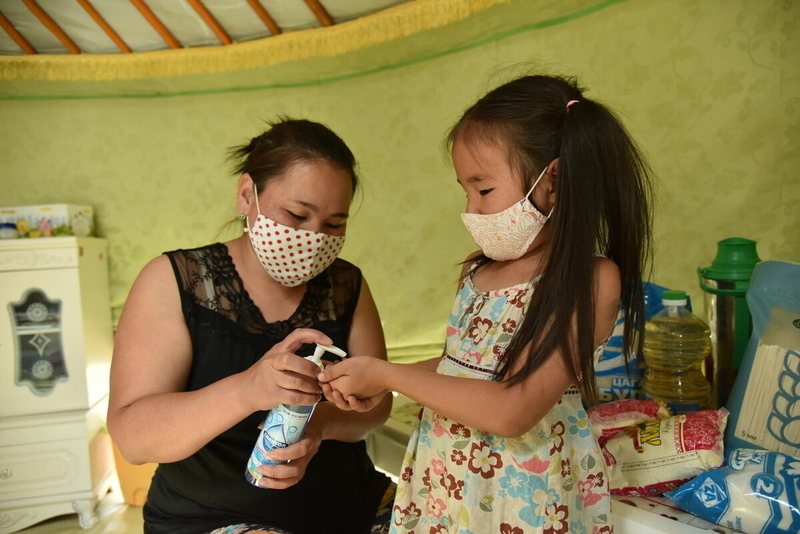 Mother and daughter use hand sanitizer