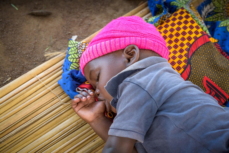 Sleeping toddler sucks his thumb in Uganda.